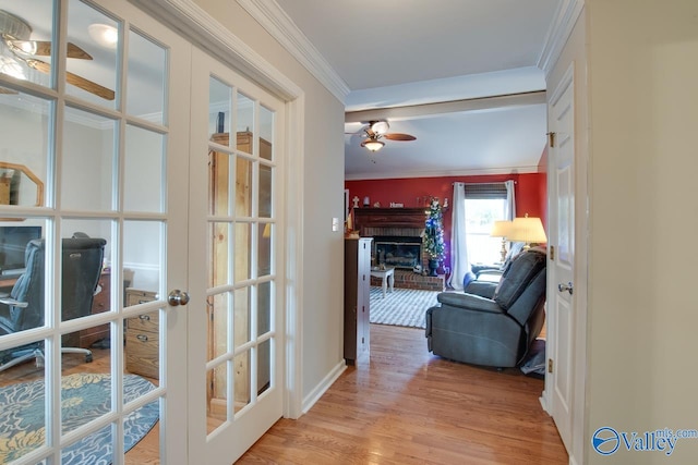 hall featuring light wood-type flooring, french doors, and ornamental molding