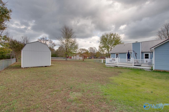 view of yard featuring a wooden deck and a storage shed