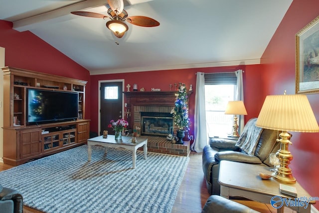 living room with ceiling fan, a wealth of natural light, hardwood / wood-style floors, and vaulted ceiling with beams