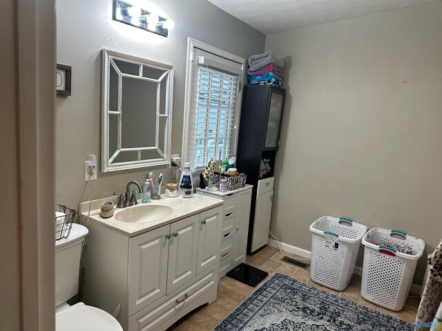 bathroom featuring vanity, toilet, and a textured ceiling