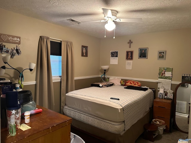 bedroom featuring ceiling fan, carpet, and a textured ceiling