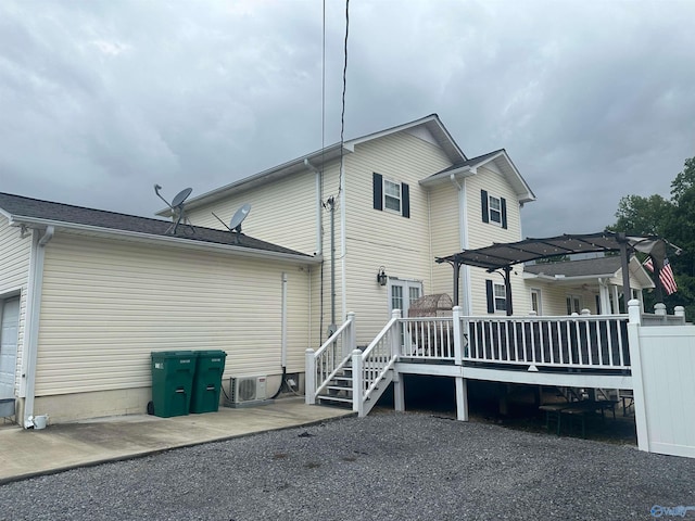 rear view of property with a deck and a pergola