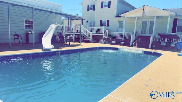 view of pool featuring a water slide and french doors