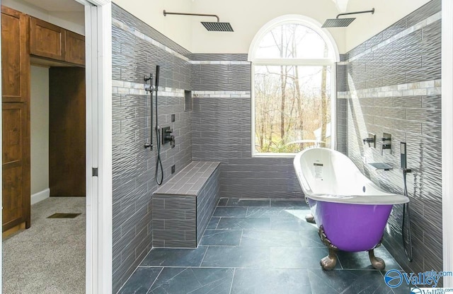 bathroom featuring tile patterned flooring, tile walls, plus walk in shower, and a wealth of natural light