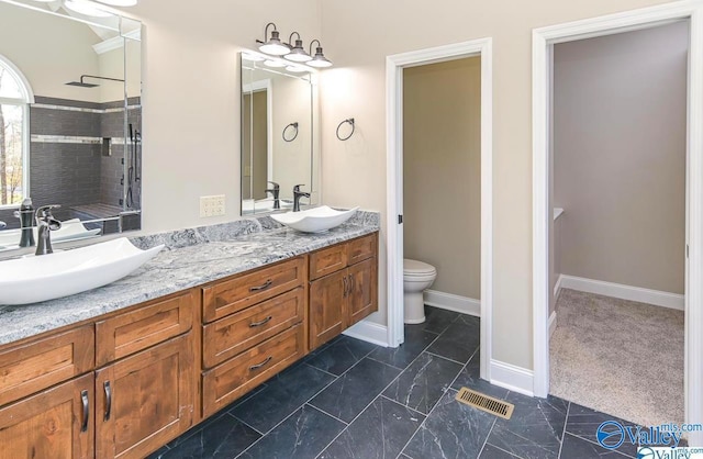 bathroom featuring dual vanity, toilet, and tile patterned floors