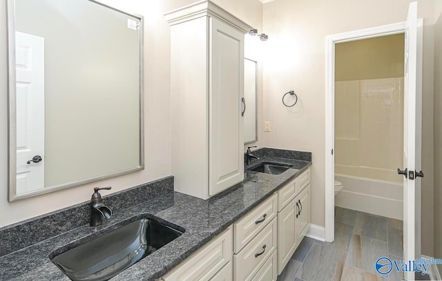 full bathroom with double sink vanity, toilet, and shower / bathtub combination