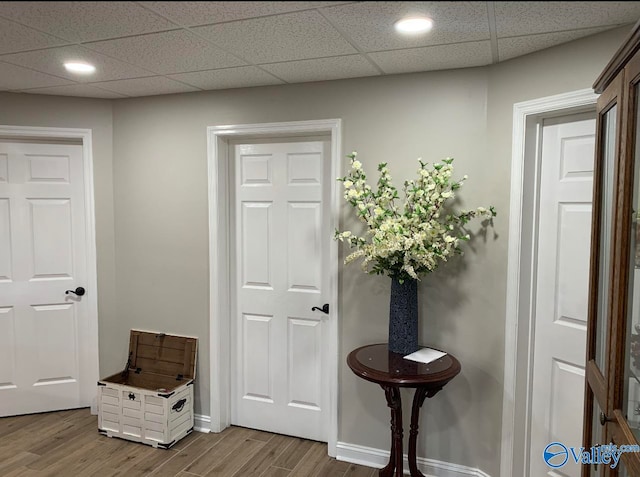 corridor with a paneled ceiling and hardwood / wood-style floors