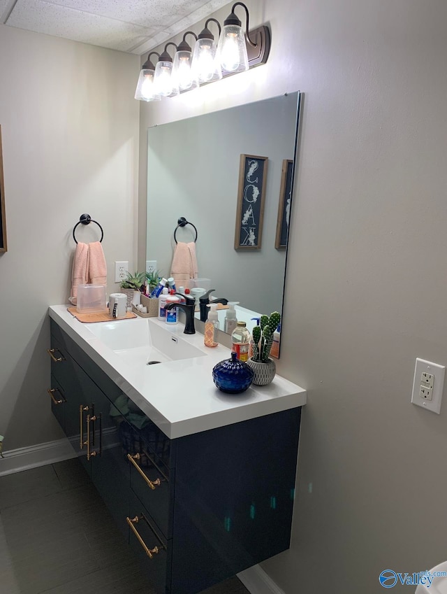 bathroom with a drop ceiling and vanity