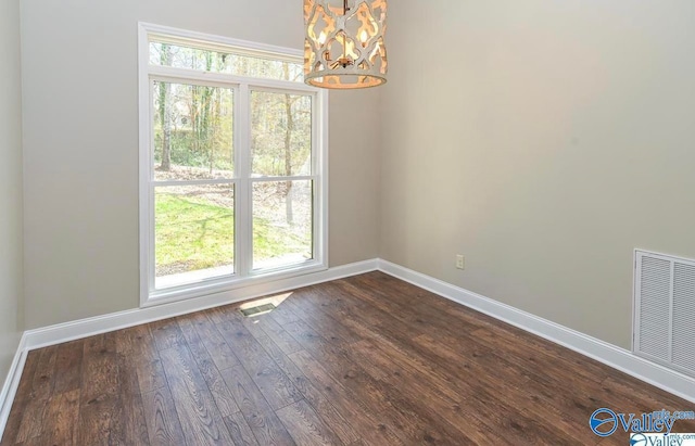 unfurnished dining area with a chandelier and dark wood-type flooring