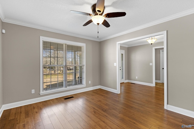 unfurnished room with crown molding, visible vents, hardwood / wood-style floors, ceiling fan, and baseboards