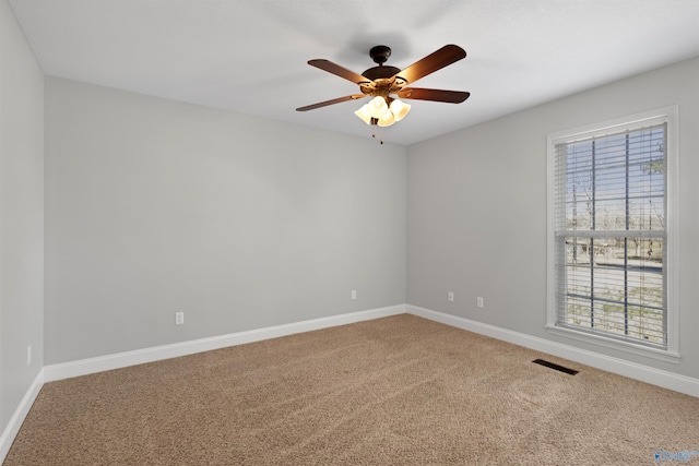 spare room featuring a ceiling fan, baseboards, visible vents, and carpet flooring