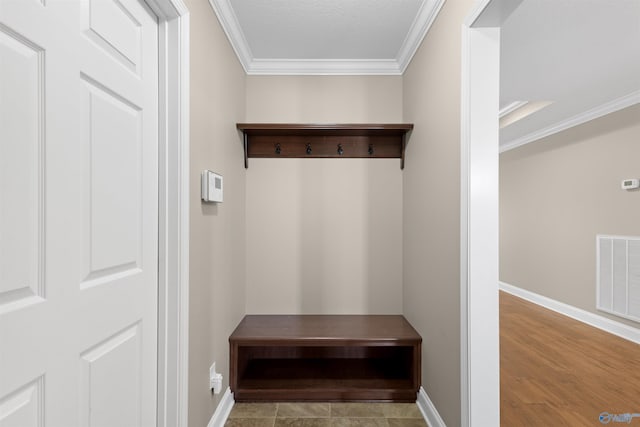 mudroom featuring baseboards, visible vents, and ornamental molding