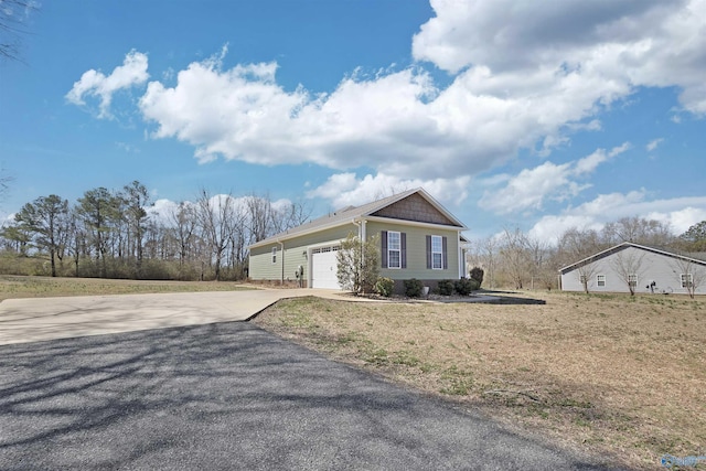 view of front of property with concrete driveway, a front lawn, and an attached garage