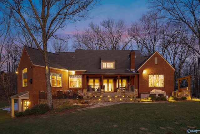 13032 Monte Vedra Rd, Huntsville, AL 35803 - back of property at dusk featuring brick siding, a yard, and a chimney