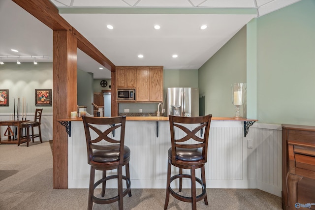 13032 Monte Vedra Rd, Huntsville, AL 35803 - kitchen with a kitchen breakfast bar, wainscoting, carpet, recessed lighting, and appliances with stainless steel finishes