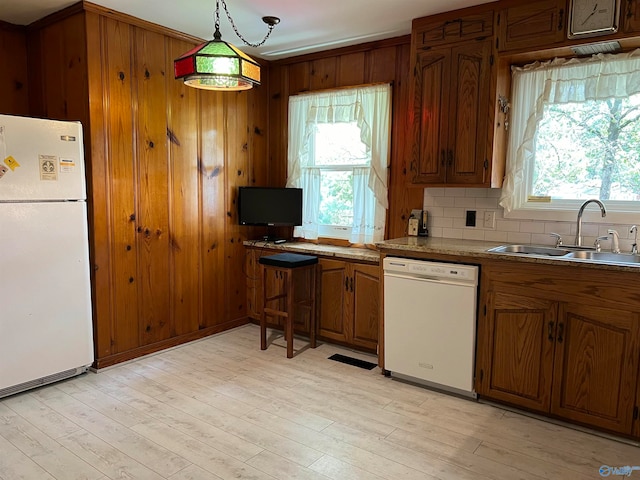 kitchen with sink, light hardwood / wood-style flooring, white appliances, and plenty of natural light