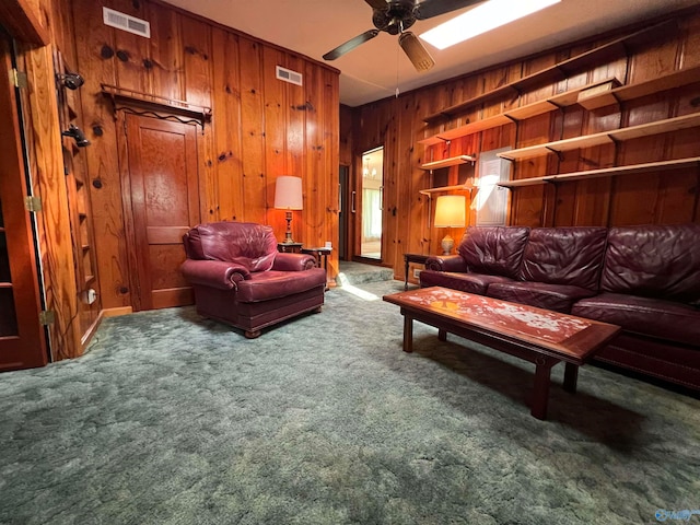 interior space with ceiling fan, wooden walls, and dark colored carpet