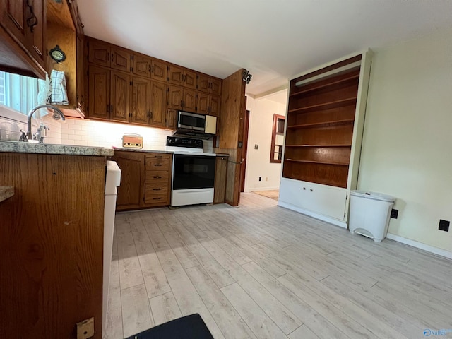 kitchen featuring light hardwood / wood-style floors, tasteful backsplash, sink, and white range