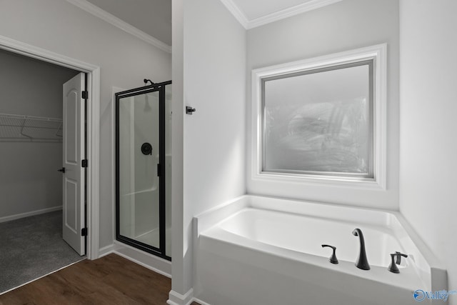 bathroom featuring wood-type flooring, ornamental molding, and independent shower and bath