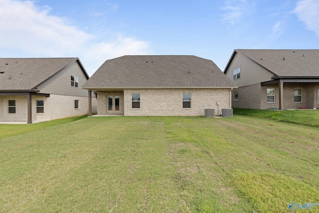 back of house with central AC and a lawn