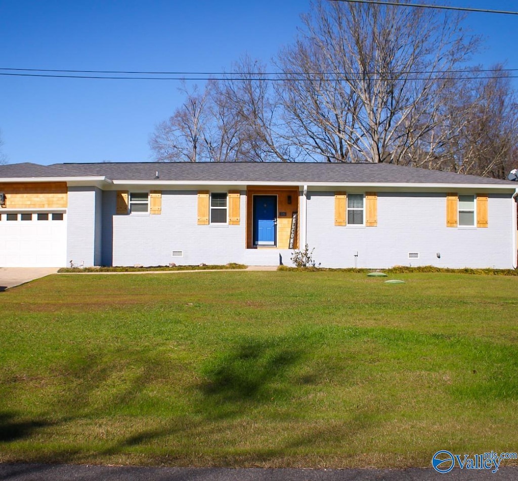 single story home featuring a garage and a front lawn