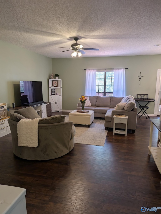 living area featuring baseboards, a ceiling fan, dark wood finished floors, and a textured ceiling