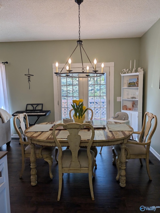 dining room with dark wood finished floors, a notable chandelier, and a textured ceiling