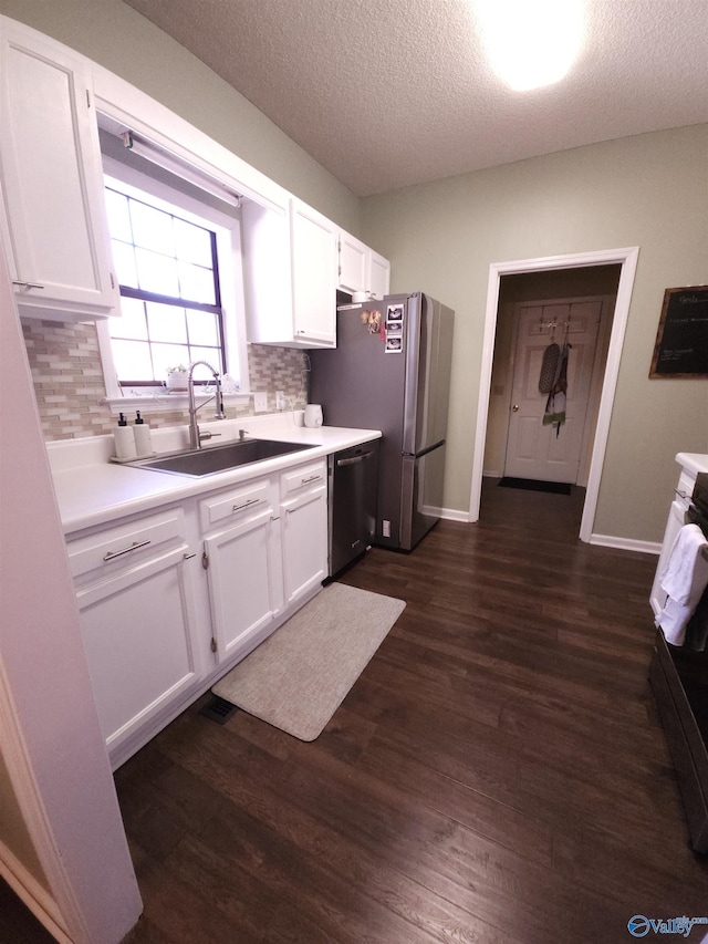 kitchen with light countertops, stove, white cabinetry, a sink, and dishwashing machine