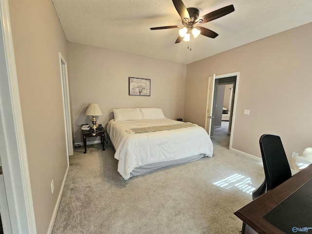 bedroom featuring light carpet, a textured ceiling, and baseboards