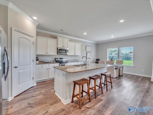 266 Dinner Tree Sq, Huntsville, AL 35811 - kitchen featuring appliances with stainless steel finishes, a sink, ornamental molding, a kitchen breakfast bar, and white cabinets