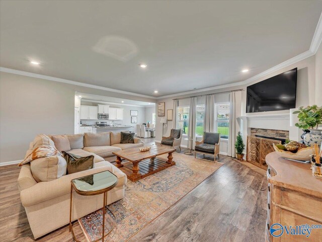266 Dinner Tree Sq, Huntsville, AL 35811 - living room featuring crown molding, light wood-style flooring, recessed lighting, a stone fireplace, and baseboards