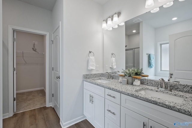 bathroom with vanity, hardwood / wood-style flooring, and a shower with door