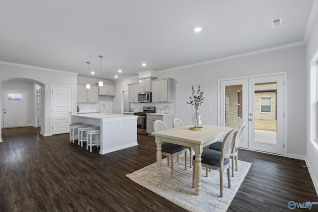 dining area featuring dark hardwood / wood-style flooring, sink, ornamental molding, and french doors