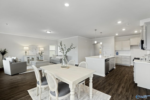 dining area with ornamental molding, dark hardwood / wood-style floors, and sink