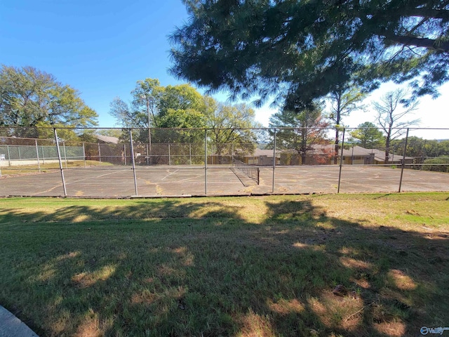 view of property's community with tennis court and a lawn