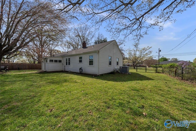 1228 W Market St, Athens, AL 35611 - rear view of house featuring a fenced backyard, a lawn, a chimney, and cooling unit