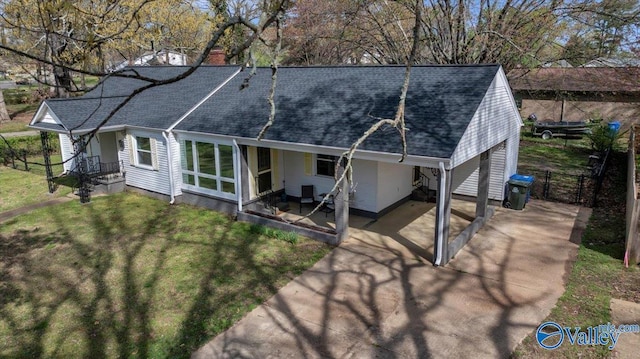 1228 W Market St, Athens, AL 35611 - rear view of house with roof with shingles, concrete driveway, an attached carport, fence, and a yard