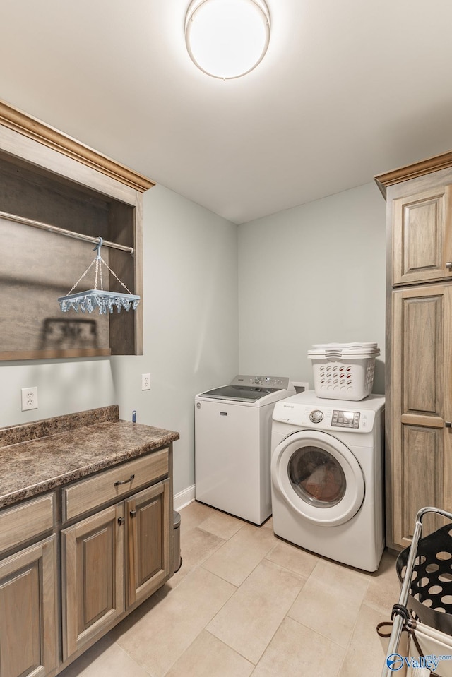 15153 Hobbs Rd, Athens, AL 35614 - laundry area featuring washing machine and dryer, baseboards, light tile patterned flooring, and cabinet space