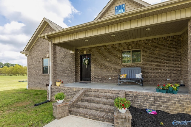 15153 Hobbs Rd, Athens, AL 35614 - entrance to property featuring brick siding, a lawn, and covered porch