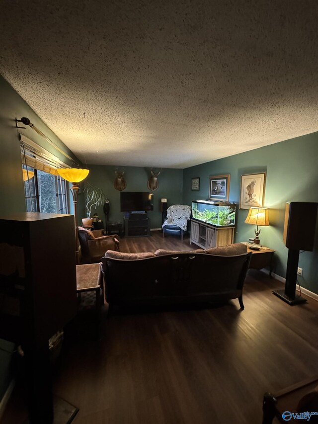bedroom featuring baseboards, a textured ceiling, and wood finished floors