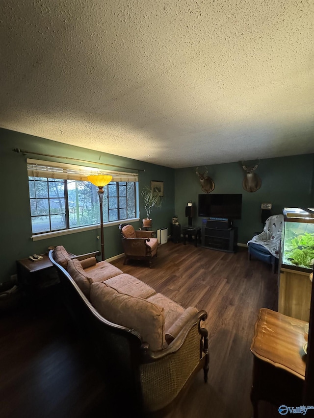 living area with a textured ceiling, baseboards, and wood finished floors