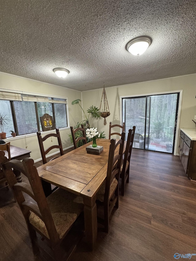 dining room featuring a textured ceiling and dark wood finished floors