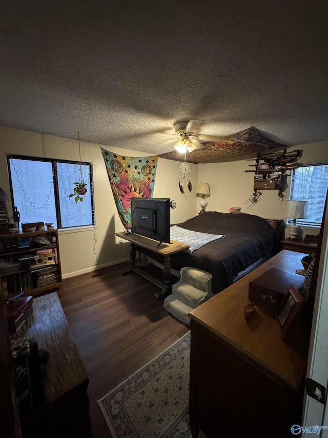 bedroom featuring a textured ceiling, baseboards, ceiling fan, and wood finished floors