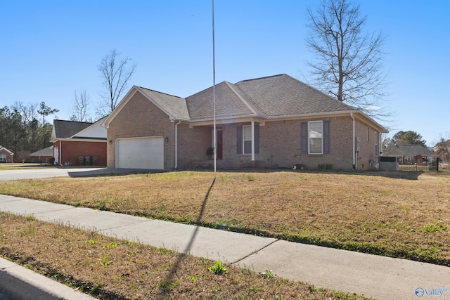 ranch-style home featuring a garage, driveway, brick siding, and a front yard