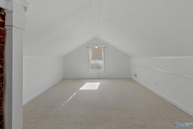 bonus room with light carpet and vaulted ceiling