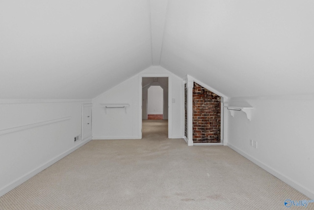 bonus room with lofted ceiling and light colored carpet