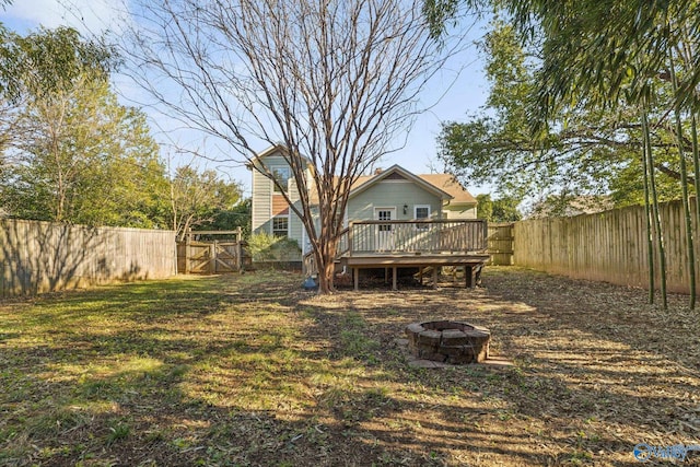 view of yard featuring a deck and an outdoor fire pit