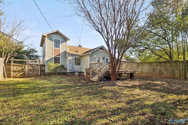 back of house with a wooden deck and a lawn