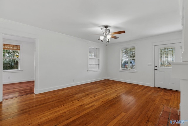 unfurnished room featuring ceiling fan, a healthy amount of sunlight, ornamental molding, and hardwood / wood-style floors