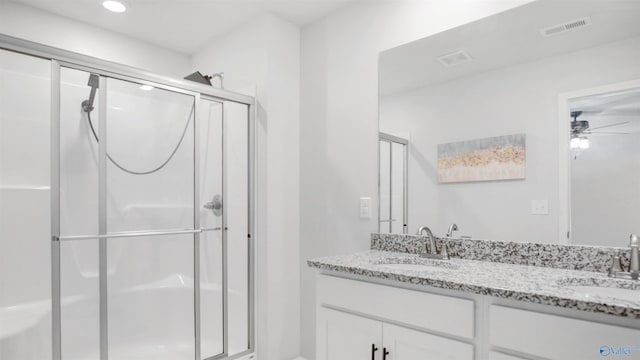 bathroom featuring a sink, a stall shower, and visible vents